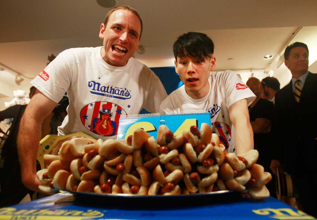 2009 年,小林尊 (Takeru Kobayashi) 和冠军乔伊切斯特纳特 (Joey Chestnut) 看着高耸的热狗托盘。