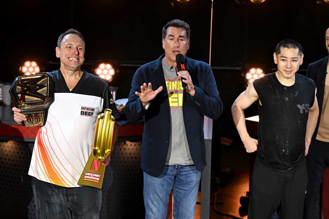 (左)乔伊·切斯特纳特 (Joey Chestnut)、罗伯·里格尔 (Rob Riggle) 和小林武 (Takeru Kobayashi) 于周一在内华达州拉斯维加斯卢克索酒店 Hyper X 竞技场举行的 LIVE Chestnut vs. Kobayashi:Unfinished Beef 节目中登台讲话。