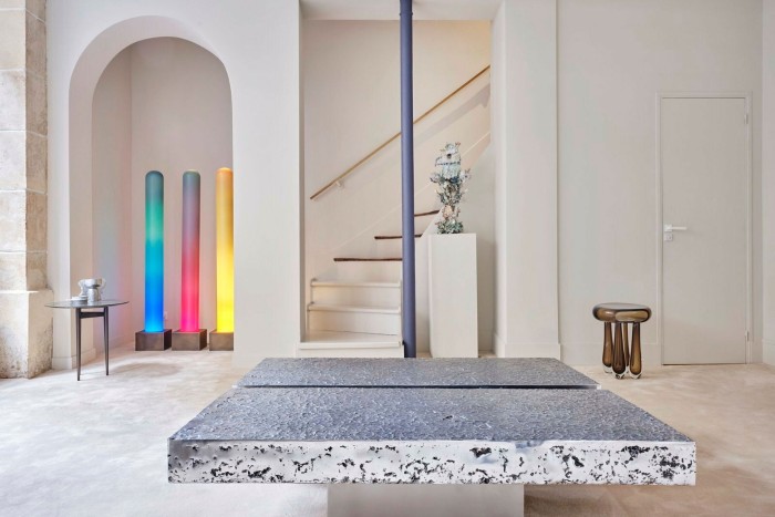 Galerie Scène Ouverte 的现代家具设计包括一张灰色大理石桌和三盏垂直彩色灯