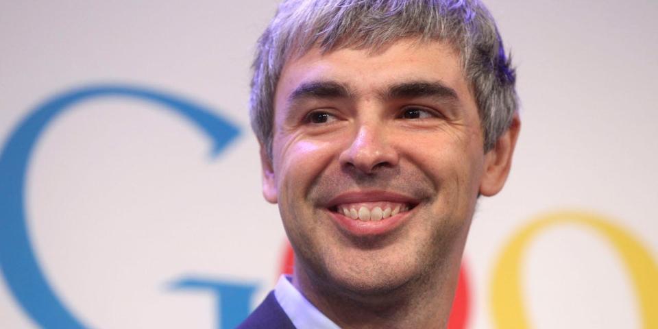 拉里·佩奇微笑,身后是 Google 标志。