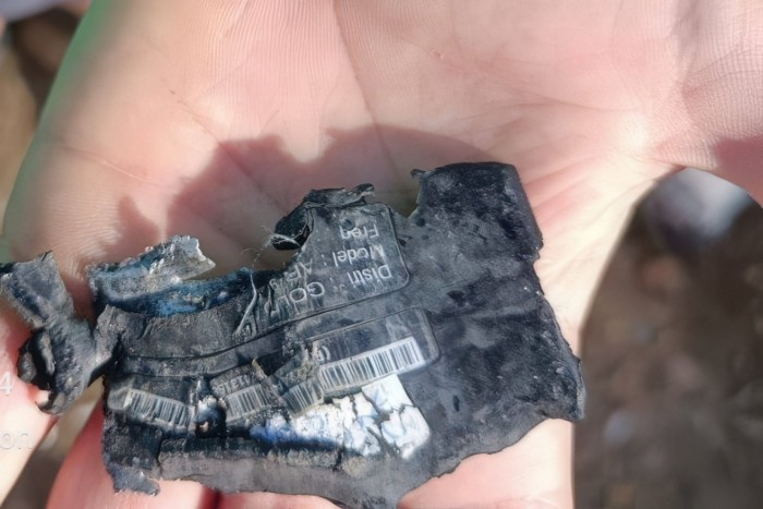 一只手显示被毁坏的寻呼机或爆炸的寻呼设备