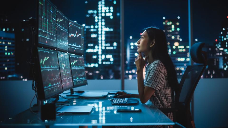 一位对冲基金分析师正在查看电脑显示器上的投资图表。