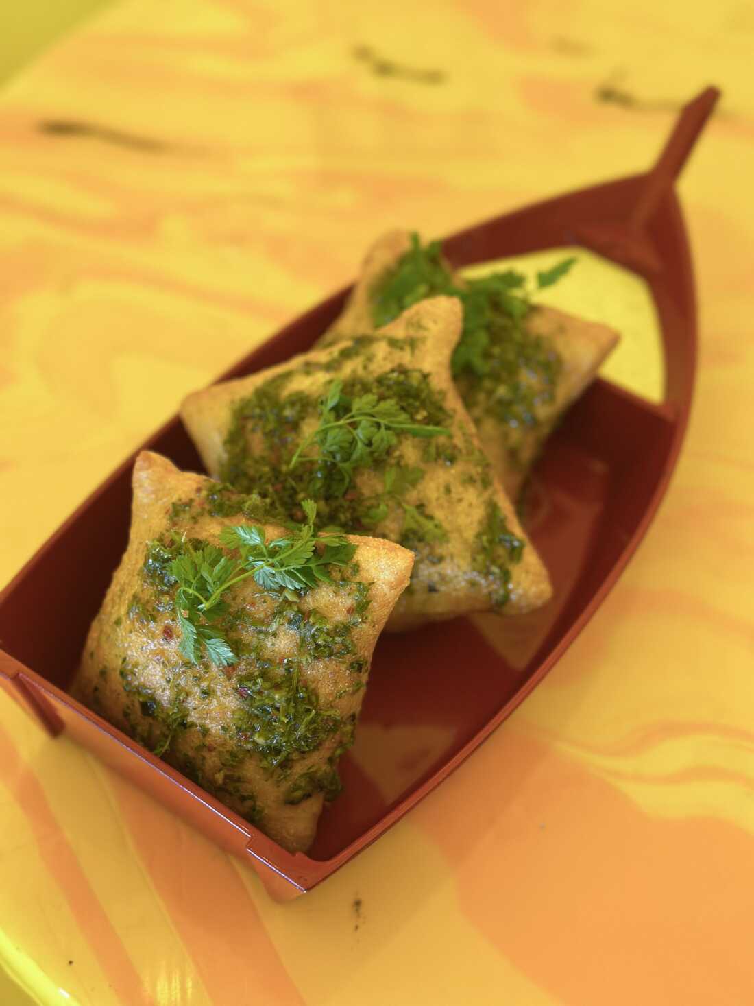 厨师大卫·墨菲 (David Murphy) 的胡萝卜顶 Chimichurri 酱,在 Shuggie 的披萨泡芙上展示。