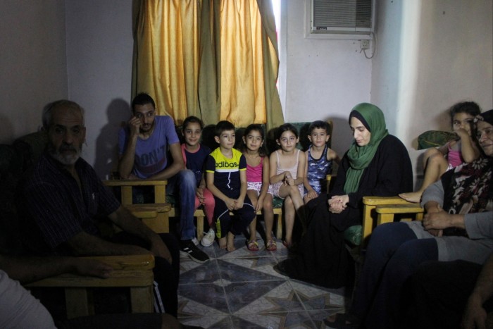 黎巴嫩一家 20 口人为了躲避轰炸而越过边境,坐在叙利亚 Sayyedah Zeinab 村的避难所里