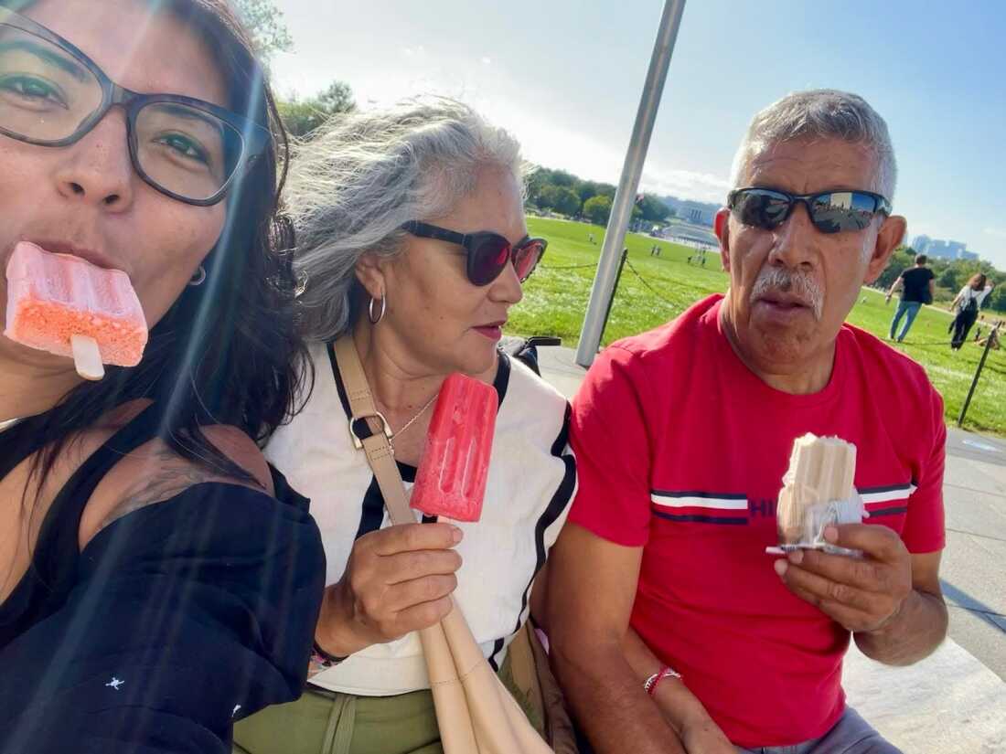阿德里安娜·加拉多 (Adriana Gallardo) 和她的父母塞西莉亚 (Cecilia) 和杰拉尔多 (Gerardo) 在华盛顿特区的华盛顿纪念碑享用帕莱塔