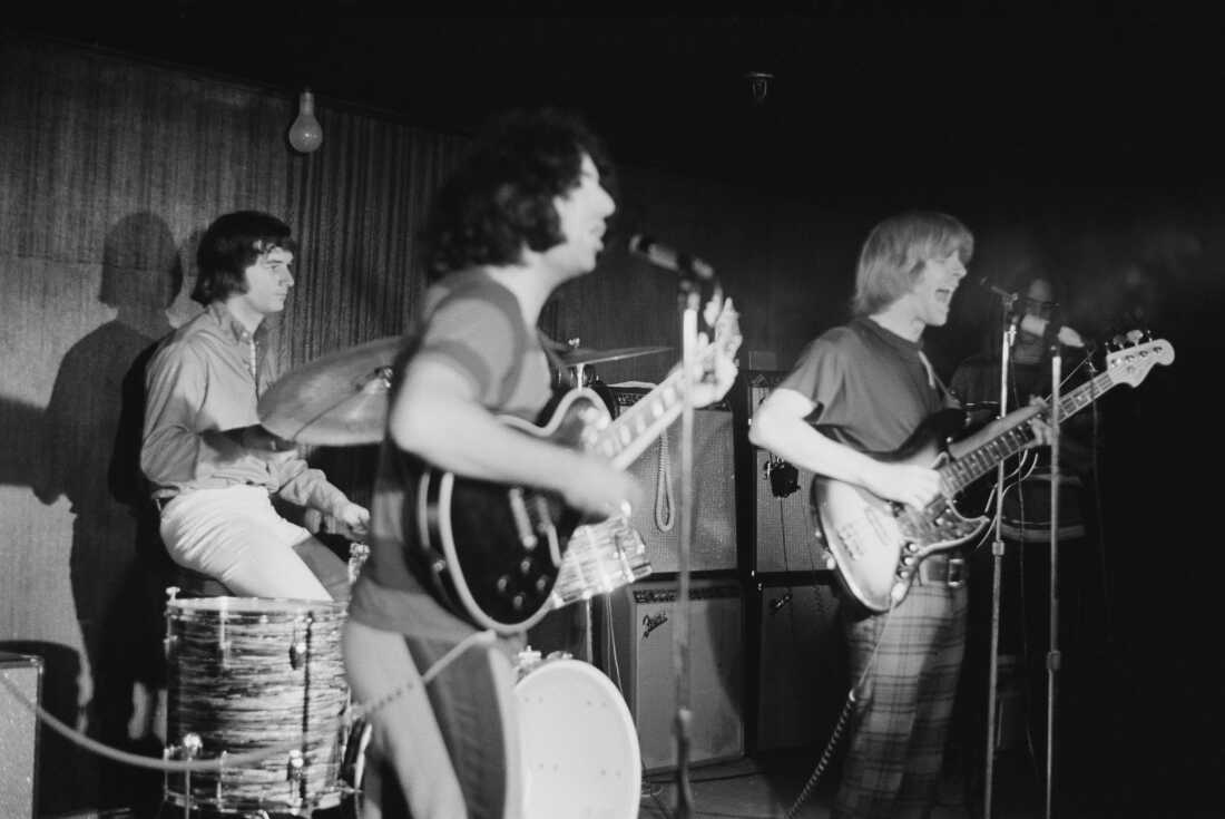 1970 年左右,感恩而死乐队的贝斯手 Phil Lesh(右)与美国摇滚乐队感恩而死乐队一起在音乐会上演奏。从左到右,鼓手比尔·克罗伊茨曼 (Bill Kreutzmann)、主唱杰里·加西亚 (Jerry Garcia) 和。 (唐·保尔森/迈克尔·奥克斯档案馆/盖蒂图片社拍摄)