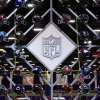 NFL 标志周围环绕着联盟 32 支球队的头盔。周一发布的一项新调查发现,三分之一的前 NFL 球员认为自己患有 CTE,这是一种与脑震荡相关的退行性脑部疾病。