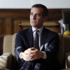 这张照片显示的是 2015 年 1 月 13 日,时任洛杉矶市长埃里克·加塞蒂 (Eric Garcetti) 在洛杉矶市政厅的办公室接受采访。他穿着深蓝色西装,打着深色图案领带,坐在扶手椅上,他双腿交叉,双手放在膝盖上方。