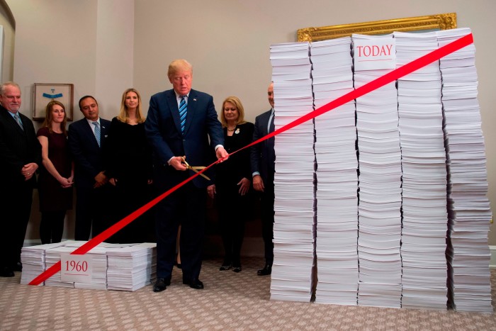 唐纳德·特朗普 (Donald Trump) 在代表 20 世纪 60 年代和当今监管的一叠文件旁边剪掉了繁文缛节。他说:“当我们完成时。” 。 。我们的水平将低于 1960 年,我们将拥有良好的监管环境”